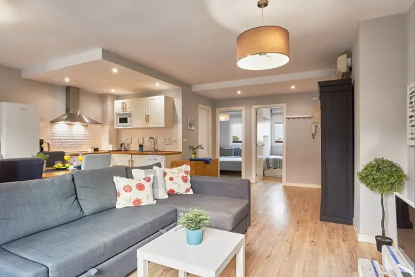 Living room with a sofa, dining table and open kitchen of H&T Dream Stays apartment in Málaga