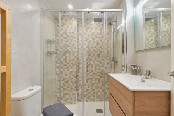 Glass shower enclosure and mirrored bathroom vanity at H&T Dream Stays apartment in Málaga