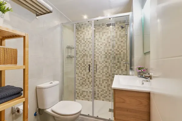 Bathroom with a walk-in shower, toilet and wooden vanity at H&T Dream Stays apartment in Málaga