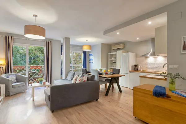 Open-plan living room and kitchen with wooden flooring at H&T Dream Stays apartment in Málaga